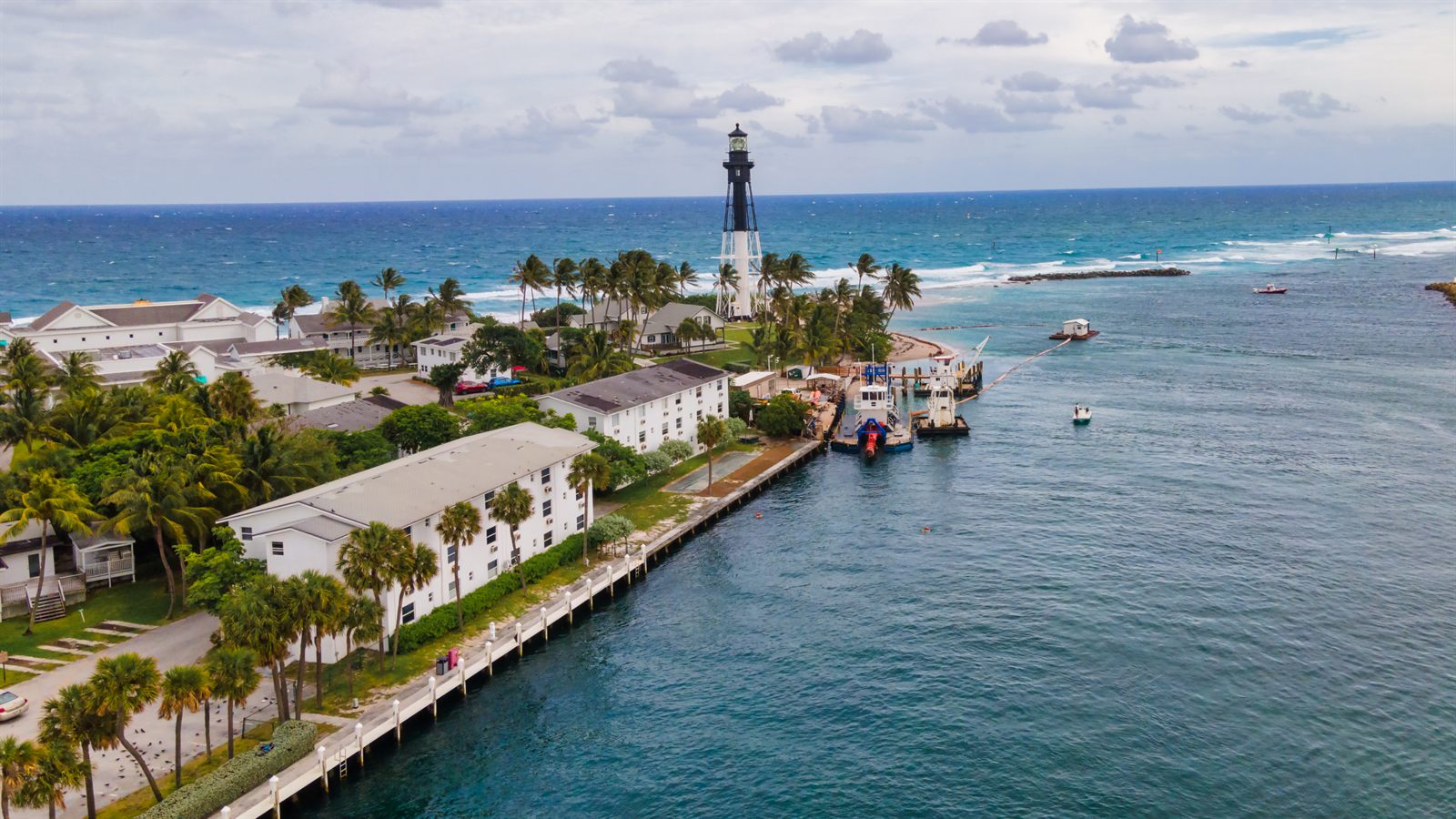 Florida inlet with a lighthouse, jetty and open sea, the kind of coast a cruise credit card helps you reach